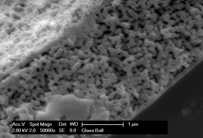 ARC Hitachi high-magnification SEM micrograph of nanoporous wall with 1 µm scale bar